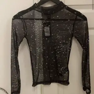 En genomskinlig långärmad tröja i mesh med små stjärndetaljer på. Aldrig använd, bara testad.