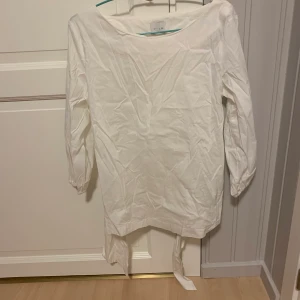 Långärmad top/blus storlek 38 - Långärmad top/blus med knytband. Köpt på Vila. Testad en gång. Lite liten 38, men större än vanlig 36. 