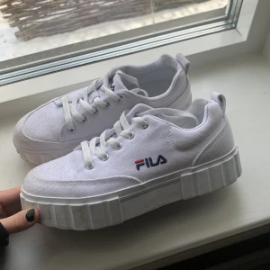 Vita sneakers  - Säljer mina vita Fila sneakers då de ej kommer till användning💕 köptes förra året och användes i 3 dagar men ej sedan dess. De är lite smutsiga men då det är tyg kommer jag kunna tvätta de. Kontakta för fler bilder eller frågor🫶🏻priset är ej inkl. frakt💕