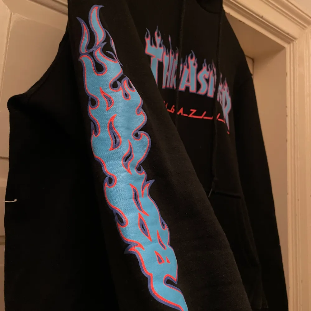 Skitcool svart imiterad Thrasher hoodie med blå detaljer. Lite liten storleken men super för de som inte vill ha oversized!. Tröjor & Koftor.