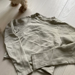 Träningströja soc - Min gamla älsklingströja!! Långärmad ribbad, mjuk och stretchig träningströja från soc. Den är lite tjockare och är i färgen beige/cream. I fint skick förutom uppe vid trapsen då den blivit nopprig pga skivstång. 