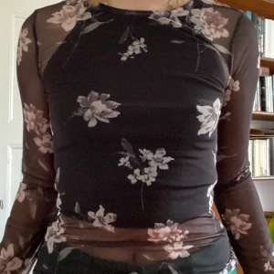 Mesh blommig långärmad top - Jättesöt mesh-tröja. Köpt för flera år sedan och används tyvärr inte längre. Sitter tajt men har någon stretch ändå.