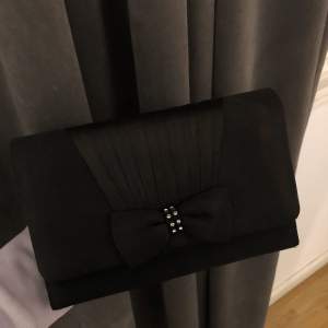 En svart fin väska som man kan hålla i handen 🖤