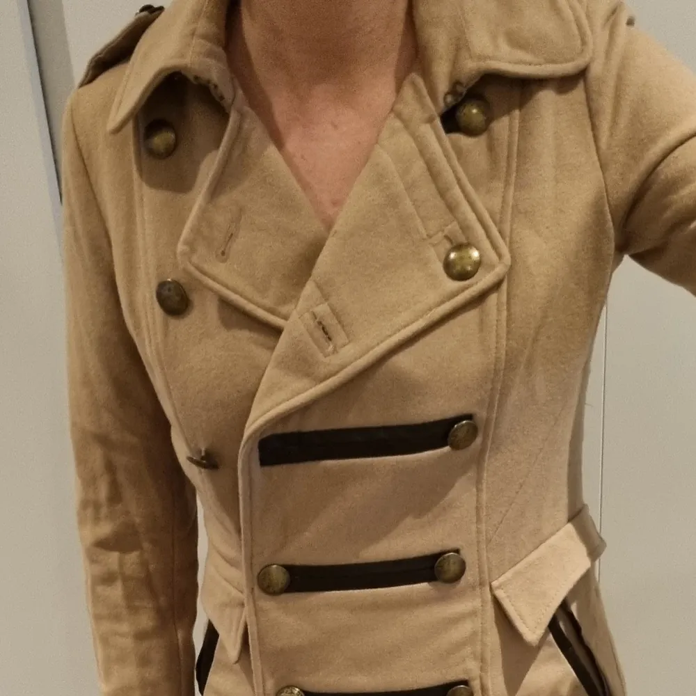 Fin beige kappa från H&M, med militärinspirerad design. Buren ett fåtal gånger, normal i storleken. :)  Storlek 36. Jackor.