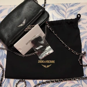 Zadig & Voltaire väska  - Zadig & Voltaire axelremsväska, svart mjukt skinn.   Storlek: bredd 17,5,  höjd 9. Mycket fint skick, som ny. Nypris 2200:- Mitt pris 1300:- 