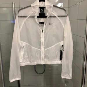 Tunn träning/löparjacka från Nike - Helt ny löparjacka från Nike i storlek L. Supersnygg och kvalitativ. Värt att tänka på är att jackan är aningen genomskinlig. Reflexer finns på både fram och baksida. Ordinarie pris: 800 kr. 