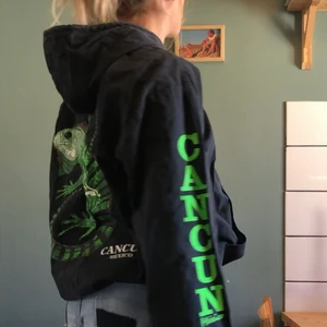 Vintage vindjacka svart  - Svart vintage tunn jacka med luva och fickor i krispigt tyg med tryck på bröst, ärmar och rygga. Stängs med dragkedja. Dragsko i midjan. Inte storleksmärkt men passar nog allt från xs-large beroende på hur man vill att den ska sitta. Jag är en small-medium och på mig sitter den enligt bild, har dragit åt dragskon i midjan så går att justera där med.