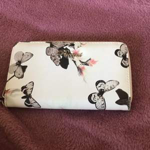 En plånbok från puccini med fjärilar på har massa fack i o är jätte fin!