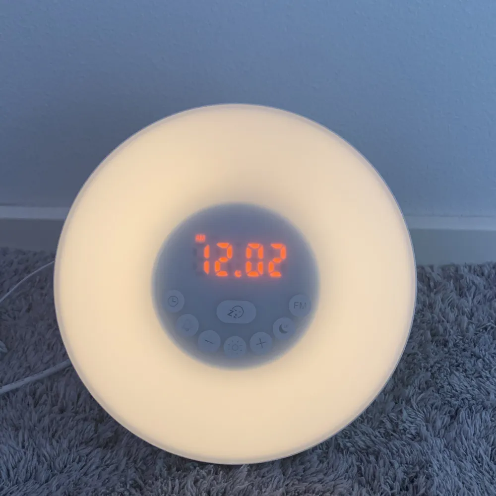 An alarm clock that works as a radio and has multiple coloque settings (white light, green, red, dark blue, purple, orange, light blue) *plus shipping*. Övrigt.