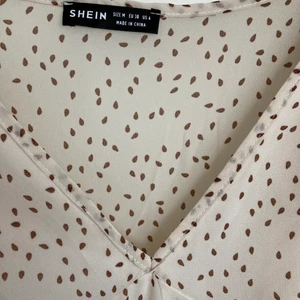 Storlek M EU38 somrig klänning frånSHEIN - Säljer en tunn skir v-ringad klänning från SHEIN med puffärmar och volanger. Mäter 41cm över midjan. Aldrig använd, bara provad. Passar fint till student, skolavslutning, dop mm Finns i Göteborg Hisingen. Säljer den för 150kr 