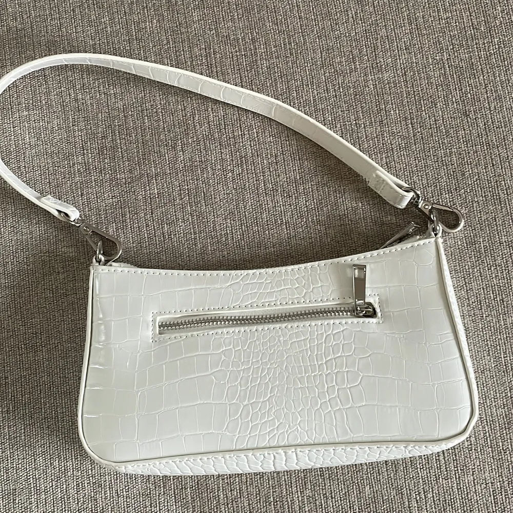 En vit axelväska med silverdragkedja som bara har används en gång🤍. Väskor.