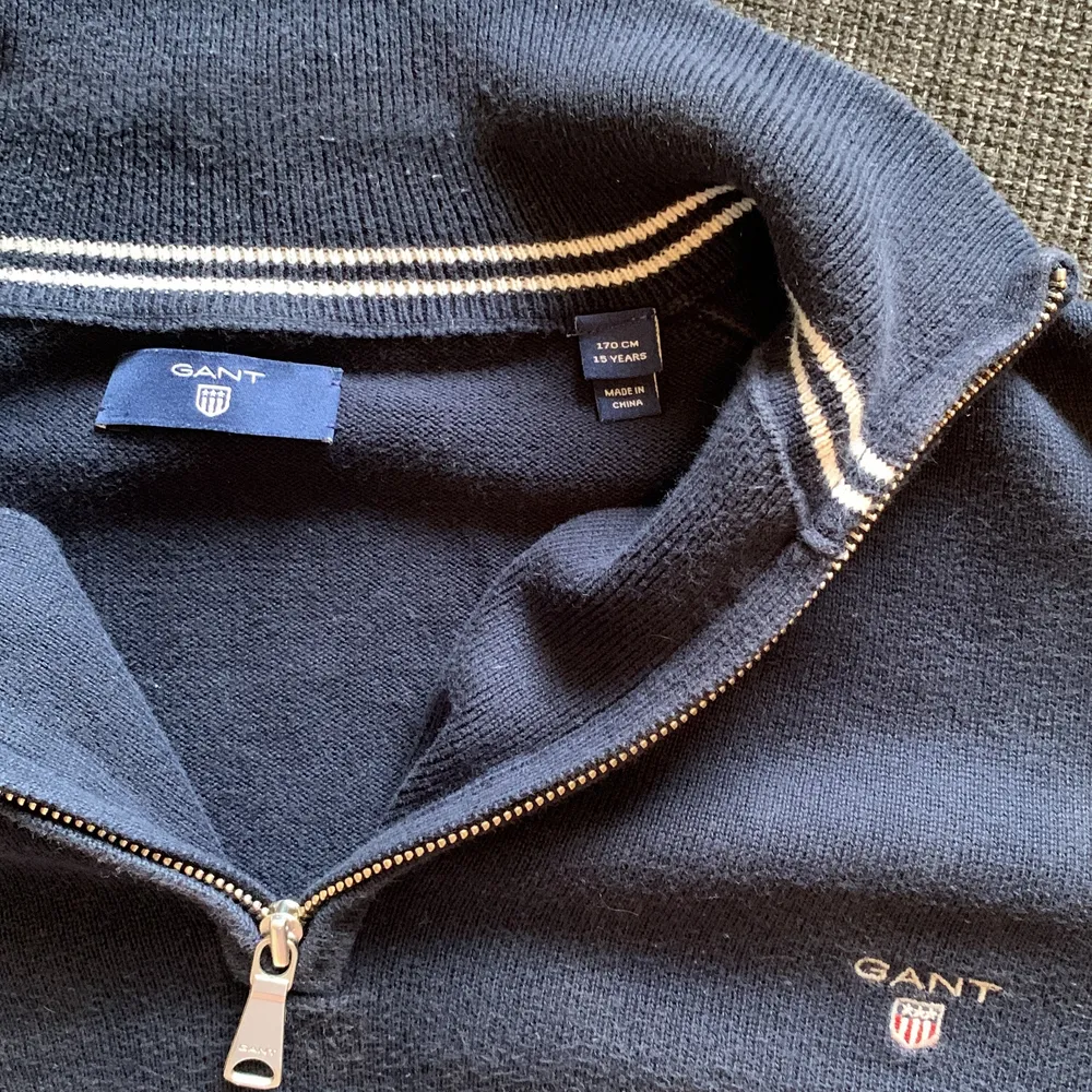 Säljer en Gant half-zip tröja i färgen mörkblå, den har inga märken/fläckar. Den har används men är i väldigt bra skick. Jag säljer den då jag har växt ur den. INGA DJUR HEMMA. ( Du står för frakten). Blusar.