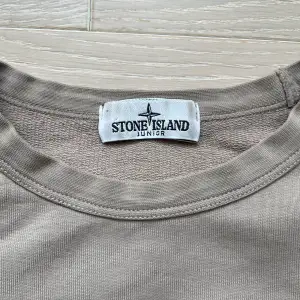 Fin Stone Island-tröja i mullvadsfärg. Inköpt på NK i Göteborg. Storlek 156 men kan nog passa ytterligare en storlek uppåt.