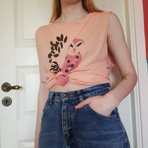 Linne med uggla - Orange linne med uggletryck. Köpt second hand, ärmarna är förmodligen avklippta av förra ägaren. Trycket är något slitet, och det finns ett litet hål på tröjan, se bild 3.