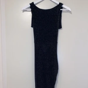 Glittrig långklänning  - En glittrig lång klänning som är perfekt för lite festligare tillfällen!  Klänningen är endast använd en gång och köptes för 350kr  Klänningen är endast använd 1 gång 