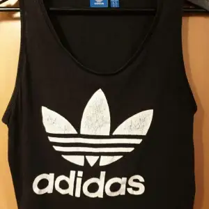 Crop top av Adidas med Adidas logga på. Storlek 40. Har litet hål på ryggen.   Köpare betalar eventuell frakt.