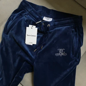 Nya Juicy Couture byxor storlek L med lappar kvar - Helt nya byxor i marinblå velour från Juicy Couture i storlek L med alla lappar kvar. Köpta på Urban Outfitters för en månad sedan, nypris 799 kr. Kan sänka priset om du köper fler grejer från mig :) Säljer mycket designerkläder och accessoarer. 