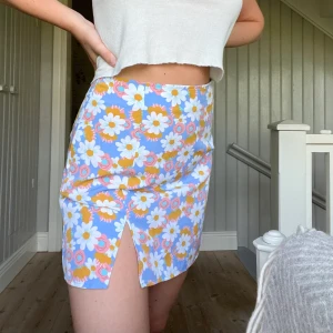 Blommig kjol - Söt blommig kjol med en liten slits i storlek M. Sparsamt använd, säljer då jag ej får användning för den. Köpare står för frakt