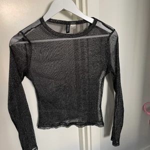 Mesh tröja  - En svart-glittrig mesh tröja från H&M, i fint skick och använd fåtal gånger. Priset är inkl frakt
