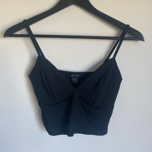 New Lool svart topp, strl 38 - Snygg svart kort topp med urringning perfekt för sommaren. Storlek 38, men passar mindre storlekar om man har större byst. Aldrig använd.