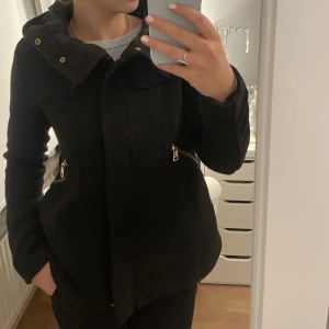 Svart trendig vår/höst jacka  - Superfin svart jacka från Zara med guldfärgade detaljer som är perfekt inför våren eller hösten. Inga defekter och väldigt sparsamt använd. Storlek XS men skulle passa en och även en S om man vill att den ska vara lite tightare ❣️