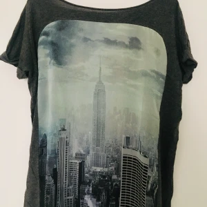 Mango t-shirt - En luftig mörkgrå t-shirt från Mango med tryck. Lite transparent framtill vid trycket. Storlek L