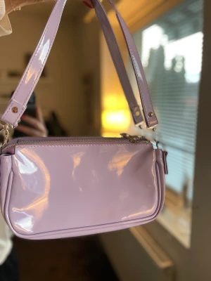 Lila väska - Aldrig kommit till användning. Lack material.💜
