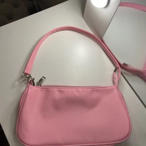 Väska - Super gullig rosa väska från shein med ett hjärta som detalj.💓  Köpt för 85kr. Helt oanvänd och därför i väldigt bra skick.💕 Köparen står för frakten!💘