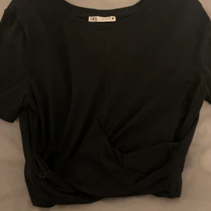Topp från Zara - Jättefin kroppad t-shirt med knytning längs ner. Fortfarande i bra skick. Först i kvarn och köparen står för frakten💕
