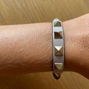 ÄKTA VALETINO ARMBAND - Nästan aldrig använt Valentino armband. Köpt i Milano på deras egna butik. Färgen är lite grå/nude. Bra skick
