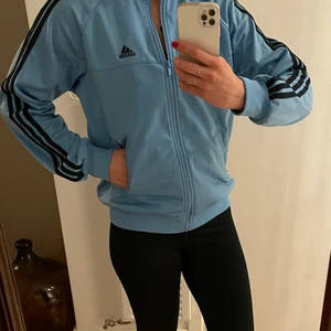 Adidas träningsjacka  - Cool träningsjacka från Adidas i skön kvalitet som håller värmen på powerwalken. Storleken är ungdom 164, passar fint en XS/S. 