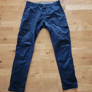 Mörkblå Cargo byxor - Cargos från EastWest i storlek 31R. Uppskattad S. Använt skick som starkt behöver en ny ägare!