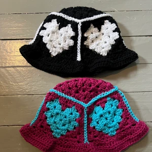 Virkad bucket hat - Virkad bucket hat med hjärtan♥️ Varje hatt virkad på beställning så du får välja färgerna helt själv🥰 Färgerna som finns ser du på sista bilden, även svart, vitt och den starka rosa som visas på en exempel ruta finns! Du får även välja om du vill ha en vågig kant (som den på bild två) eller en rak kant (som en klassisk bucket hat). Kolla även in mina andra annonser💕🥰