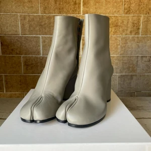 Ljusgrå Maison Margiela tabi boots - Ljusgrå Maison Margiela tabi boots storlek 36,5 aldrig använda, kommer att skickas i original förpackningen. Skriv vid frågor eller för fler bilder💖 Säljer då jag köpte fel storlek, köpta från depop för 8 000kr