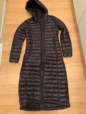 Lång dunn kappa - Säljer en lång dunn jacka i storlek 34 passar även 32 och 36. Använd 2-3 gånger ser ut som ny och i jättebra skiick. Säljer då den inte kommer till användning. Köpt för 1500