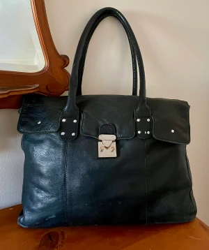 Stor väska, äkta läder - En stor läderväska i mjukt och fint äkta läder/skinn. Cirka 42x30cm och 8cm på bredden. Inte exakta mått. Det får plats med laptop, sladdar, sminkväska, tröja utan problem. Den är finast med saker i eftersom den är mjuk. 