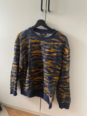 Blåmönstrad collage tröja - Blåmönstrad collage tröja från lee. Bra skick men används ej. Herr modell men passar som unisex.