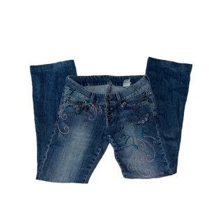 Lågmidjade jeans - LÅGMIDJADE JEANS MED FINA DETALJER PÅ     SKICK: Byxorna är i bra skick och har inga defekter.                                          MÅTT: Midjemåttet: 76cm Innerbensmått: 77cm