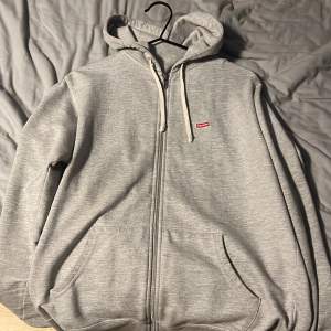 En grå supreme bloxlogo zip hoodie i storlek  medium, sitter lite tajt på mig som är 187