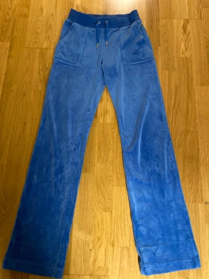 Juicy Couture byxor - Snygga Juicy Couture byxor i färgen Regatta storlek XS.  Har varit uppsydda så finns små märken längst ner på benen, syns dock inte vid användning.  Är i bra skick, köptes i oktober 2022.   Kan skickas och finns att hämta i Jönköping!