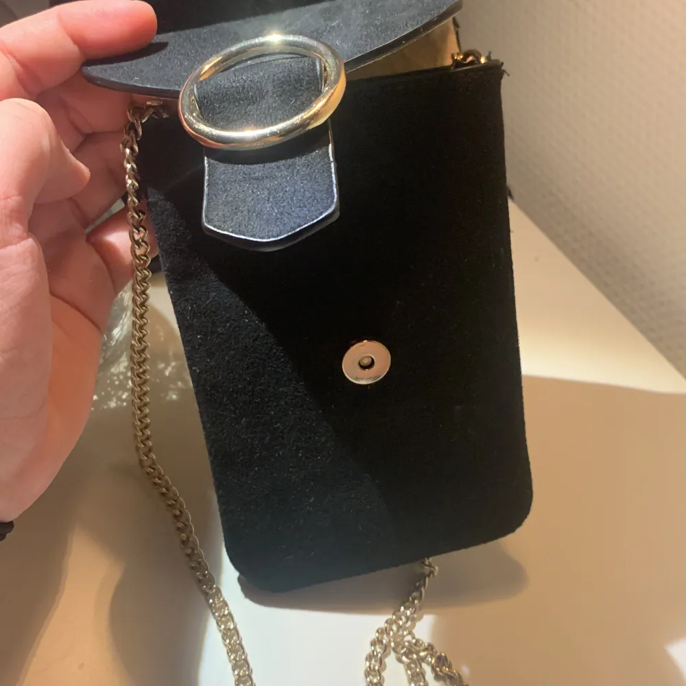 Här har vi en svart mobil väska med guld detaljer. Använd 4-5 gånger Max.. Väskor.