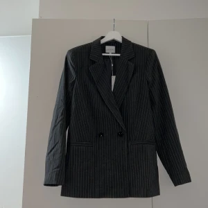 Mörkgrå Kavaj från vila, Storlek 36 - Oanvänd kavaj från vila, endast testad, säljes pga felköp av storlek, alla lappar kvar inklusive extra knapp som ingår. 