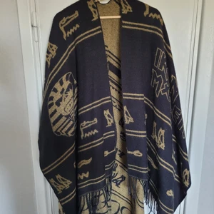 Cool poncho eller sjal Iron Maiden - En ascool poncho/sjal som blivit använd en gång. Iron Maiden merch Powerslave-albumet, inköpt på EMP, limited edition. Nypris ca 500kr. Katt finns i hemmet, rökfritt.