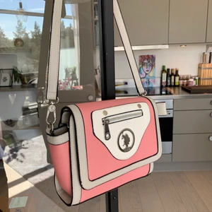 Oanvänd US Polo Assn väska - Handväska i en magisk rosa färg från US Polo Assn. Inköpt för många år sedan men aldrig använd. Lappen sitter kvar i väskan, se bild. Superfin att använda nu under sommaren!