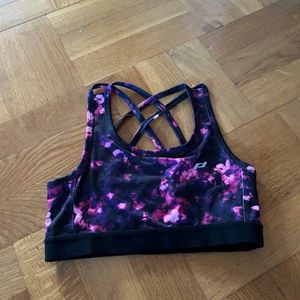 Sporttopp med lila/rosa mönster  - Oanvänd sporttopp med lila/rosa mönster, från protouch köpt på Intersport