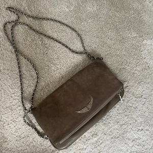 Zadig & Voltaire väska i brun mocka - Superfin Zadig väska i brun mocka, flera bra fack, ett större i själva delen som viks över, ett inre, och ett litet på utsidan, alla med dragkedja. 