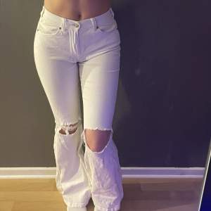 Ett par vita utsvängda dr.denim jeans med ”hål” på båda knäna. Lite ut stretchat på vissa ställen som man kan se på bilden, men annars inga skador eller slitningar. Sitter jätte bra, S men passar även M och XS. Byxorna är inte uttöjda.