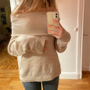 Off-shoulder tröja!  - Jättefin stickad tröja i en beige/ nästan rosa aktig färg! Går att ha offshoulder men även som en stor polo. Köpt från H&M. Jätteskön och inte stickig alls💕