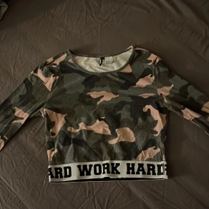 Kamouflagefärgad magtröja - Magtröja med långa ärmar. Fint skick, sparsamt använd. Texten ”hard play hard work” finns på ett typ resorband i slutet av tröjan. Från H&M (divided), storlek XS. Köparen står för frakten och all betalning sker via Swish. Bara att höra av dig vid frågor 🙂