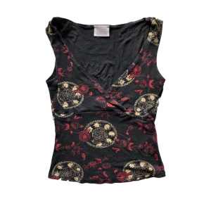 Topp - Unik tanktop från Pimkie med rött och beiget mönster. Slutar precis under naveln och passar storlek XS-M. Lagad under vänstra armhålan där stygnen gått upp lite. Köpare står för frakt. 